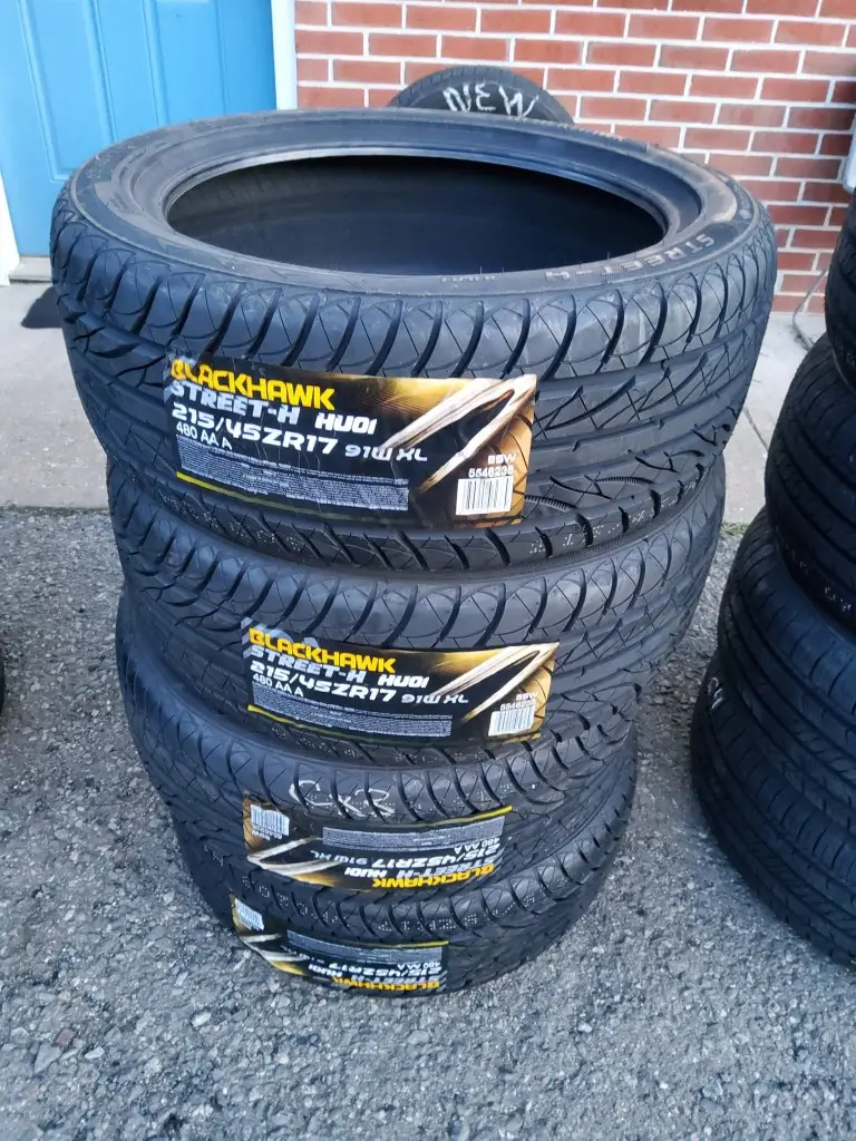 A stack of tires labeled "BLACK HAWK," showcasing their design.